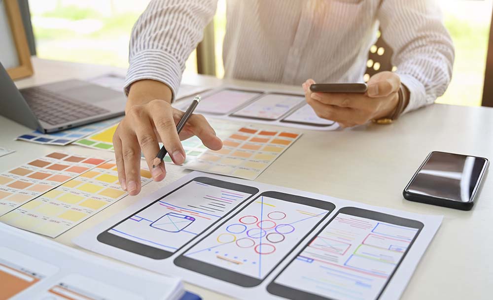 Person sitting down reviewing different mobile interface designs