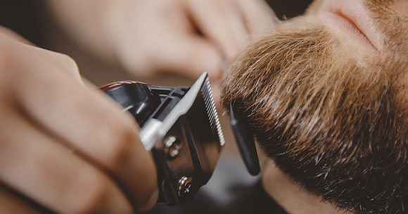 Baber shaving a customer's beard