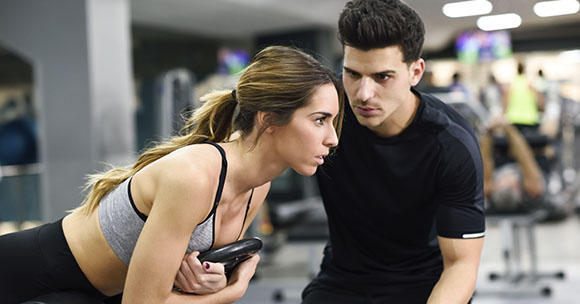 Personal trainer on the gym with a customer